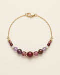 Midnight Rouge handcrafted natural tourmaline and freshwater pearl bracelet with an 18K gold-coated sterling silver chain on a Pearled Ivory background.