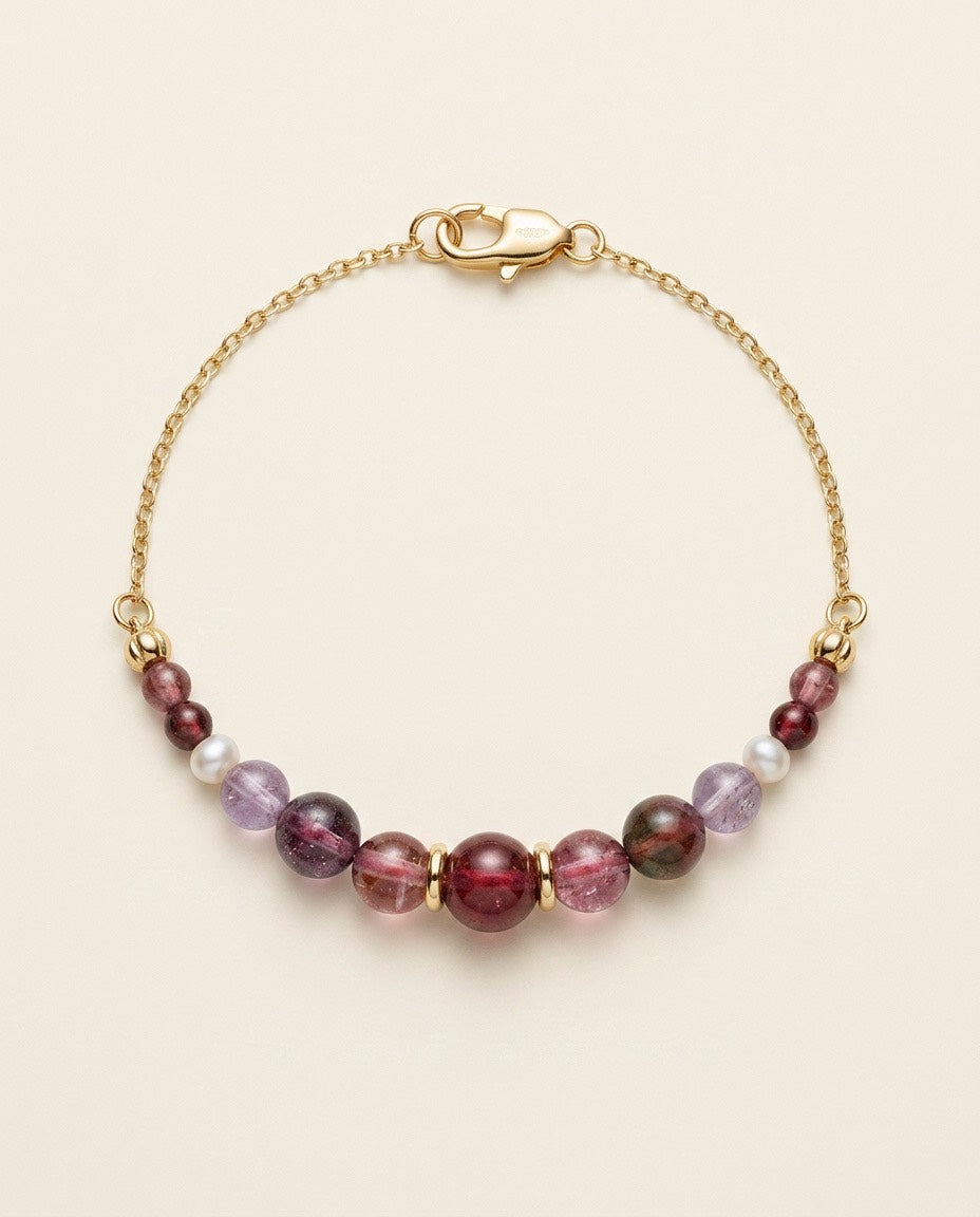 Midnight Rouge handcrafted natural tourmaline and freshwater pearl bracelet with an 18K gold-coated sterling silver chain on a Pearled Ivory background.