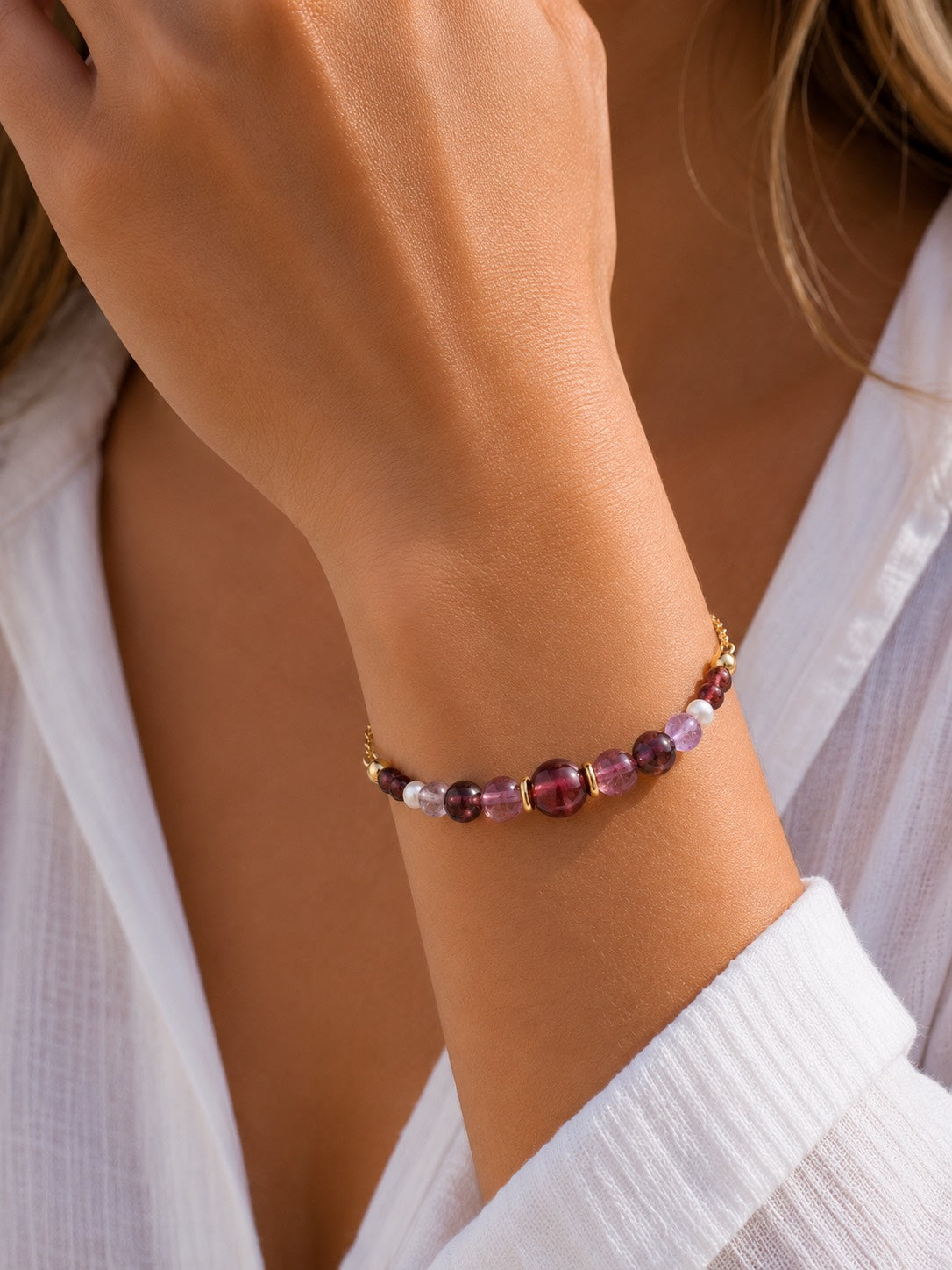 Midnight Rouge handcrafted natural tourmaline and freshwater pearl bracelet with an 18K gold-coated sterling silver chain on a Pearled Ivory background.