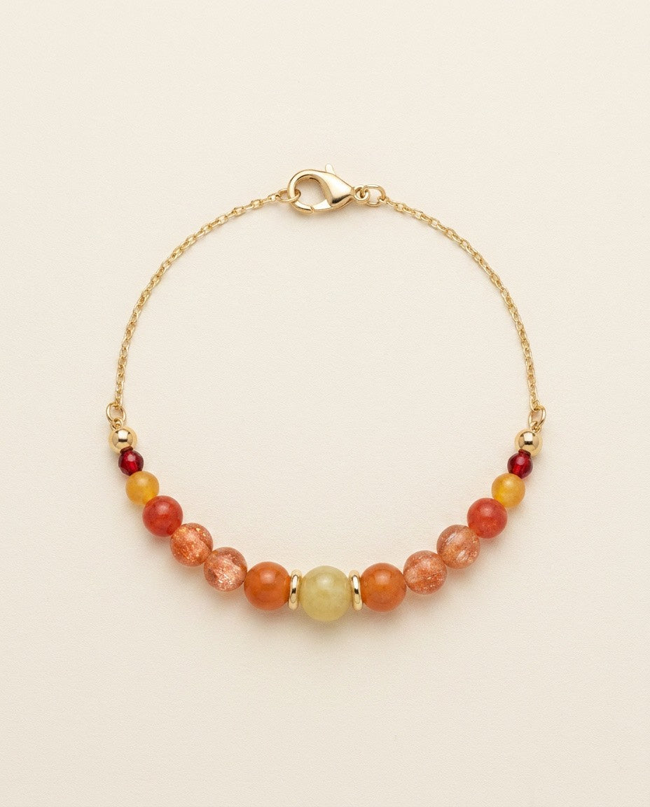 Soleil d'Ambre handcrafted natural sunstone and jade gemstone bracelet with an 18K gold-coated sterling silver chain on a Pearled Ivory background.