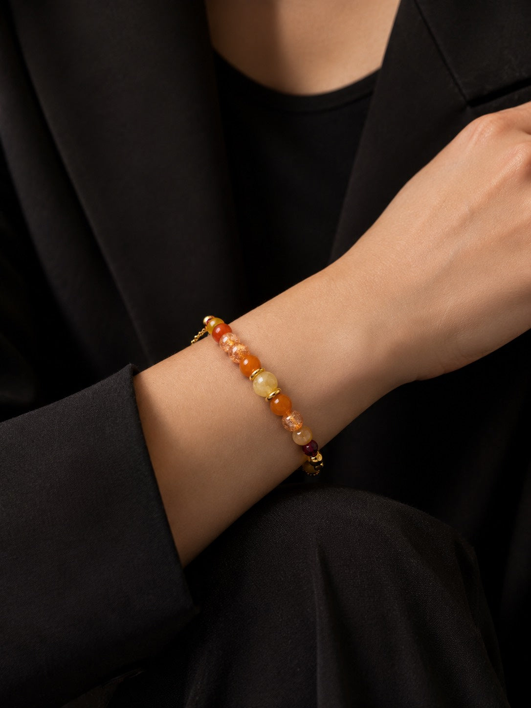 Soleil d'Ambre handcrafted natural sunstone and jade gemstone bracelet with an 18K gold-coated sterling silver chain on a Pearled Ivory background.